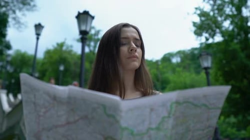 Woman with Map in City Park Finds Her Way