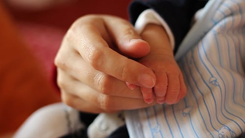 Loving Parent Holding Newborn Baby's Hand Gently