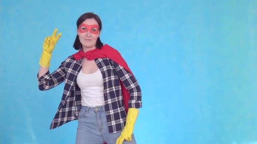 Jeune femme super-héros femme au foyer dansant sur fond bleu