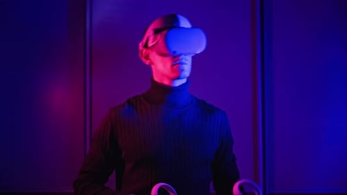 Man Wears VR Headset in a Neon Lit Room