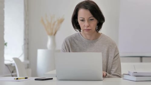 Adult Woman Coughing at a Laptop