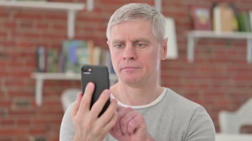 Man Using a Smartphone Indoors