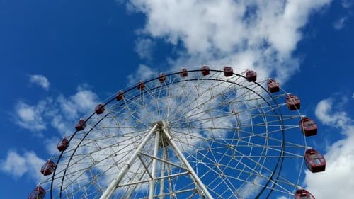 Time Lapse of Large Ferris Wheel Spinning Around on a Bright Sunny Day with Clouds Moving