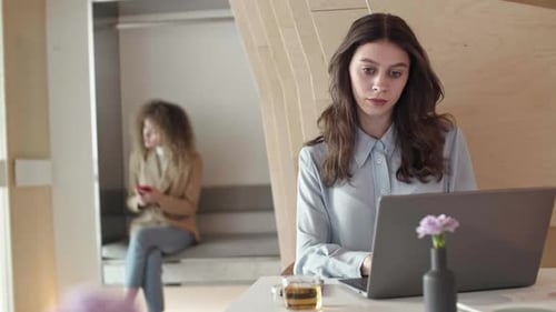 Une femme cadre travaille pendant que sa collègue se repose