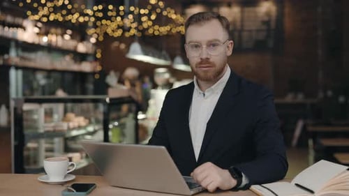 Portrait of Businessman Working in Cafe and Using Laptop