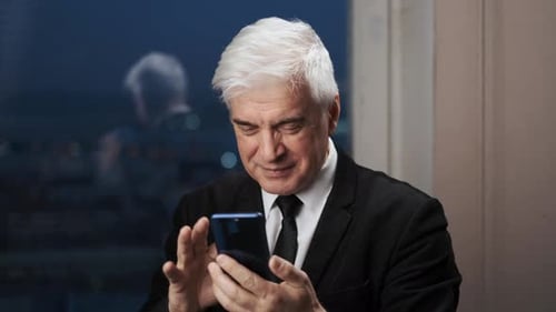 Man Uses Smartphone in Modern Urban Setting at Night