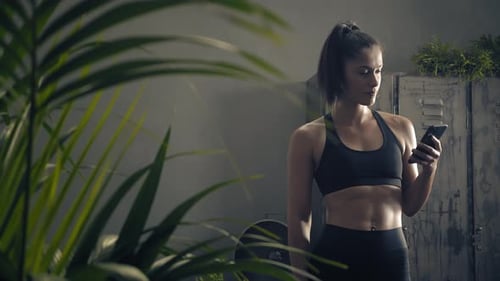 Athletic Woman Using Phone After Workout