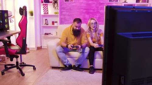 Couple Playing Video Games in Colorful Lit Living Room