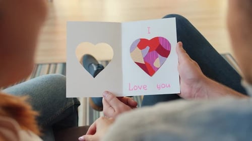 Slow Motion of Happy Couple Looking at St. Valentine's Day Card Embracing