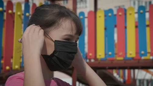Girl Puts on Face Mask at Colorful Playground