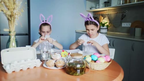 Funny Little Sisters Wearing Bunny Ears Painting Eggs on Easter Day