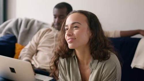 Smiling Woman With Man and Laptop on Sofa