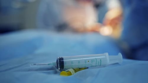 Instrumental Surgical In Operating Room. Plastic syringe on the table.