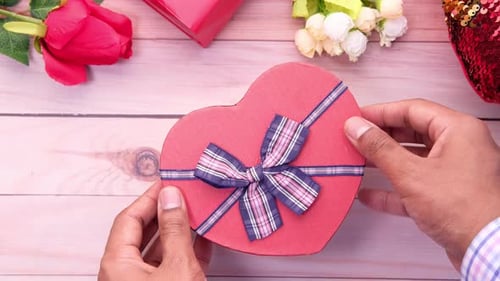 Top View of Man Hand Opening Heart Shape Gift Box