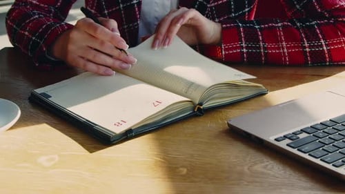 Woman Is Writing List to Do In Planner