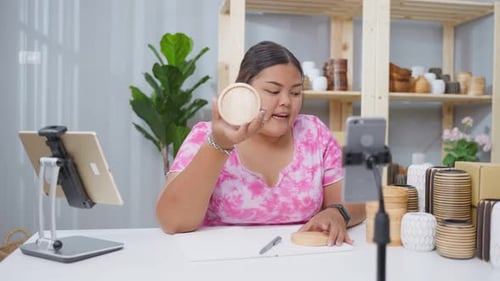 Asian business woman sell vase product online live streaming at home.