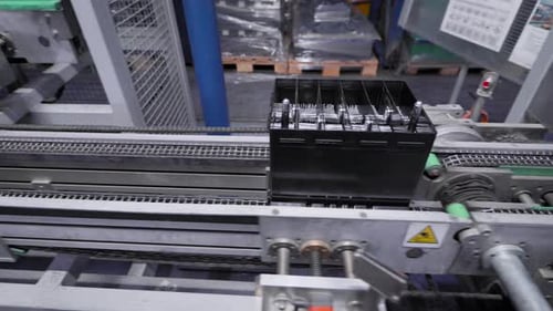 Ligne automatique pour l'assemblage de batteries de voiture. Les batteries noires se déplacent et s'accumulent sur le