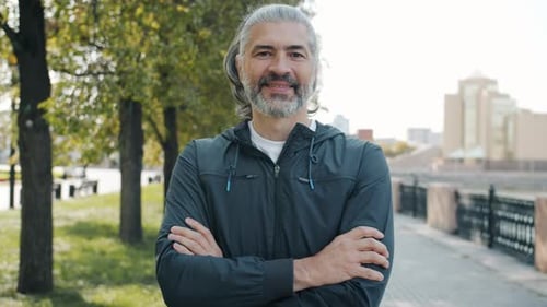 Gray Haired Man Smiling Outdoors on Walking Path