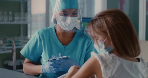 Black Female Doctor Vaccinating Girl During Epidemic