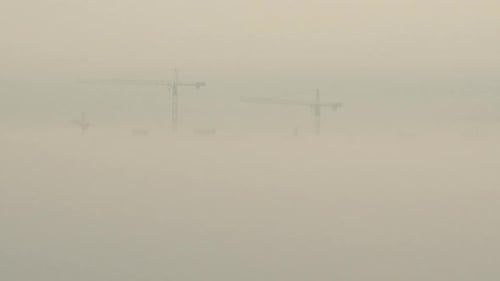 Aerial View. A Construction Cranes In The Fog On The Building Construction