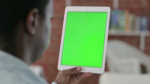 Rear View of African Man Using Tablet with Chroma Screen