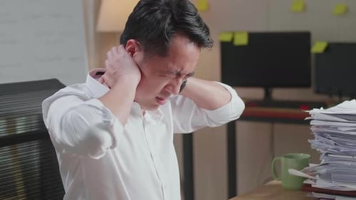 Close Up Of Asian Man Having Backache While Working Hard With Documents At The Office