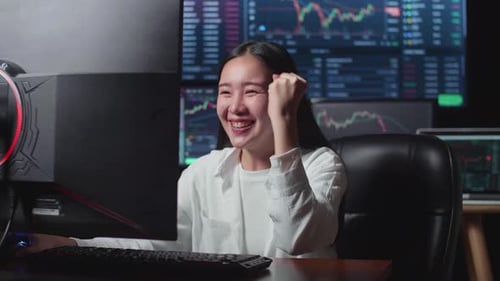 Enthusiastic Woman in Office Looking at Computer