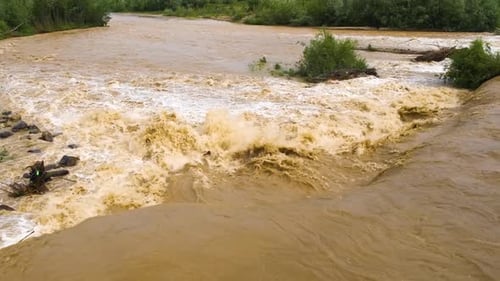 Wide dirty river with muddy water in flooding period during heavy rains in spring.