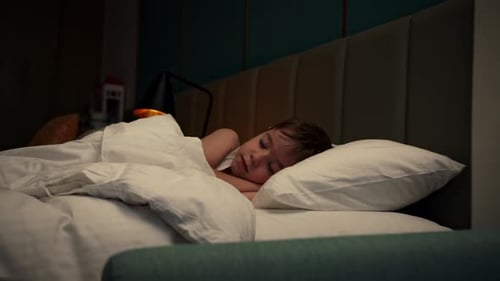 Young Child Sleeping Peacefully in Bed at Night