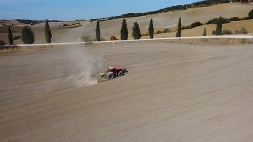 Tractor preparing wheat rural field, plowing ground soil aerial view