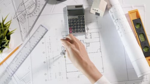 Architect drawing with divider compass on house plan blueprint paper