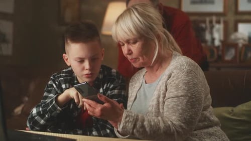 Child Teaching Adult Smartphone Use Indoors