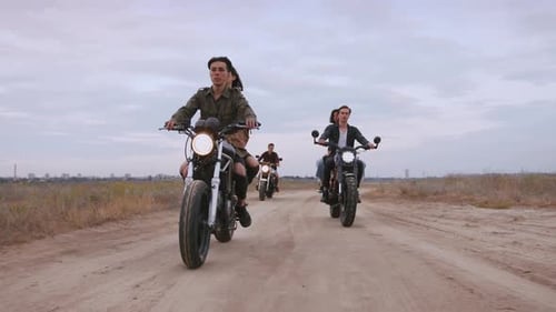 Grupo de jóvenes en moto en la playa por la noche