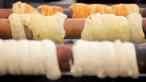 Delicioso tostado Trdelnik en palitos de madera a alta temperatura, cocina checa