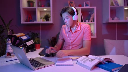 Student Studies at Desk with Laptop and Books