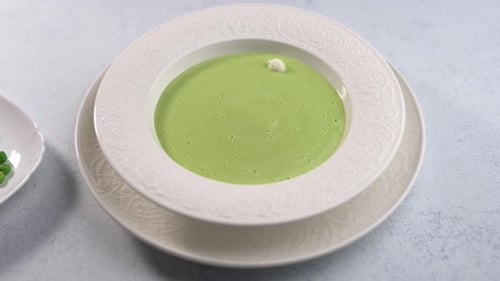 Decorating Creamy Pea Soup with Peas and Cream