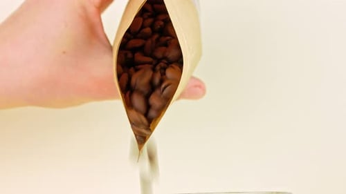 Coffee beans pouring from kraft paper pouch bag on light background cafe 4K Freshly roasted grains
