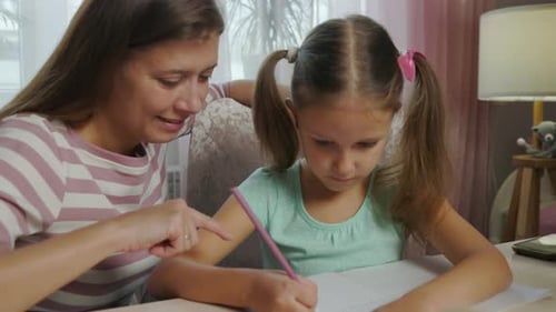 Mother And Daughter Doing Homework From School Together