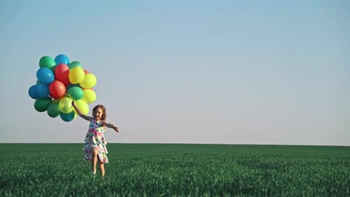 Girl Running with Colorful Balloons in Green Field