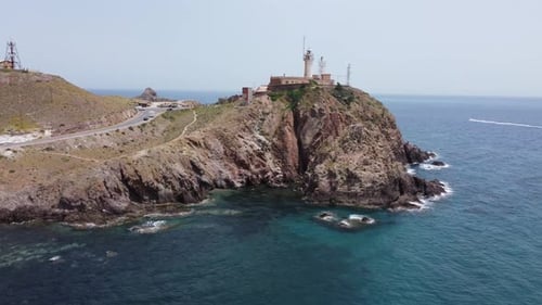 um einen Leuchtturm fliegen, der auf einer Klippe steht