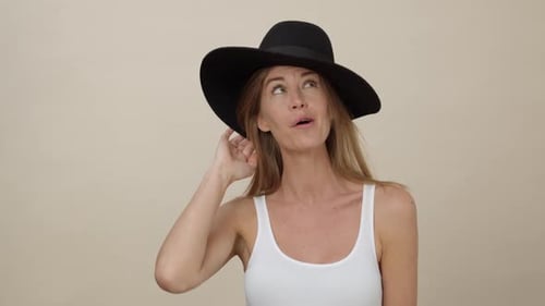 Woman Laughing While Modeling a Black Hat
