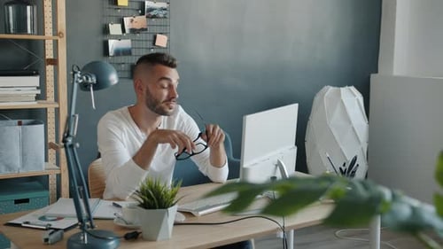 Tired and Sleepy Man Working with Computer in Office Typing Touching Face and Eyes