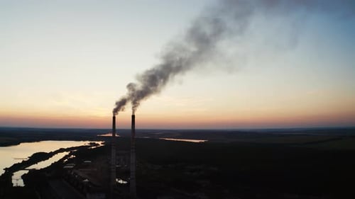 Factory near the river at sunset