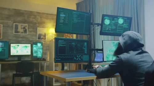 Hooded Figure Typing at Computer Monitors