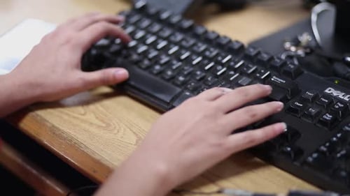 Teclado de uma senhora digitando de perto, tiro com as mãos