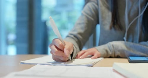 Woman study the note on paper at library