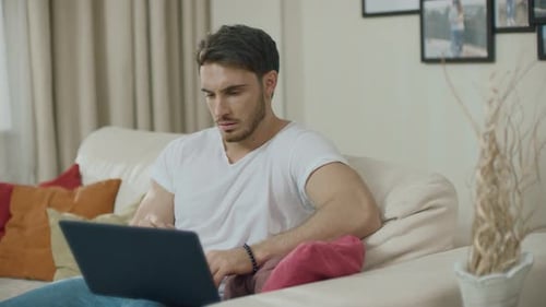 Homem de negócios preocupado trabalhando no laptop no sofá. Homem chateado