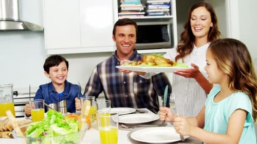 Happy Family Eating Meal Together in Kitchen