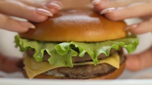 Double Patty Burger Close-Up With Hands