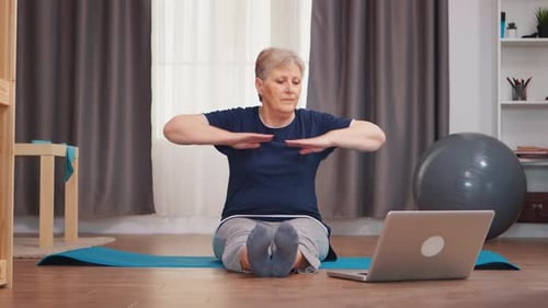 Senior Woman Stretching at Home with Online Video